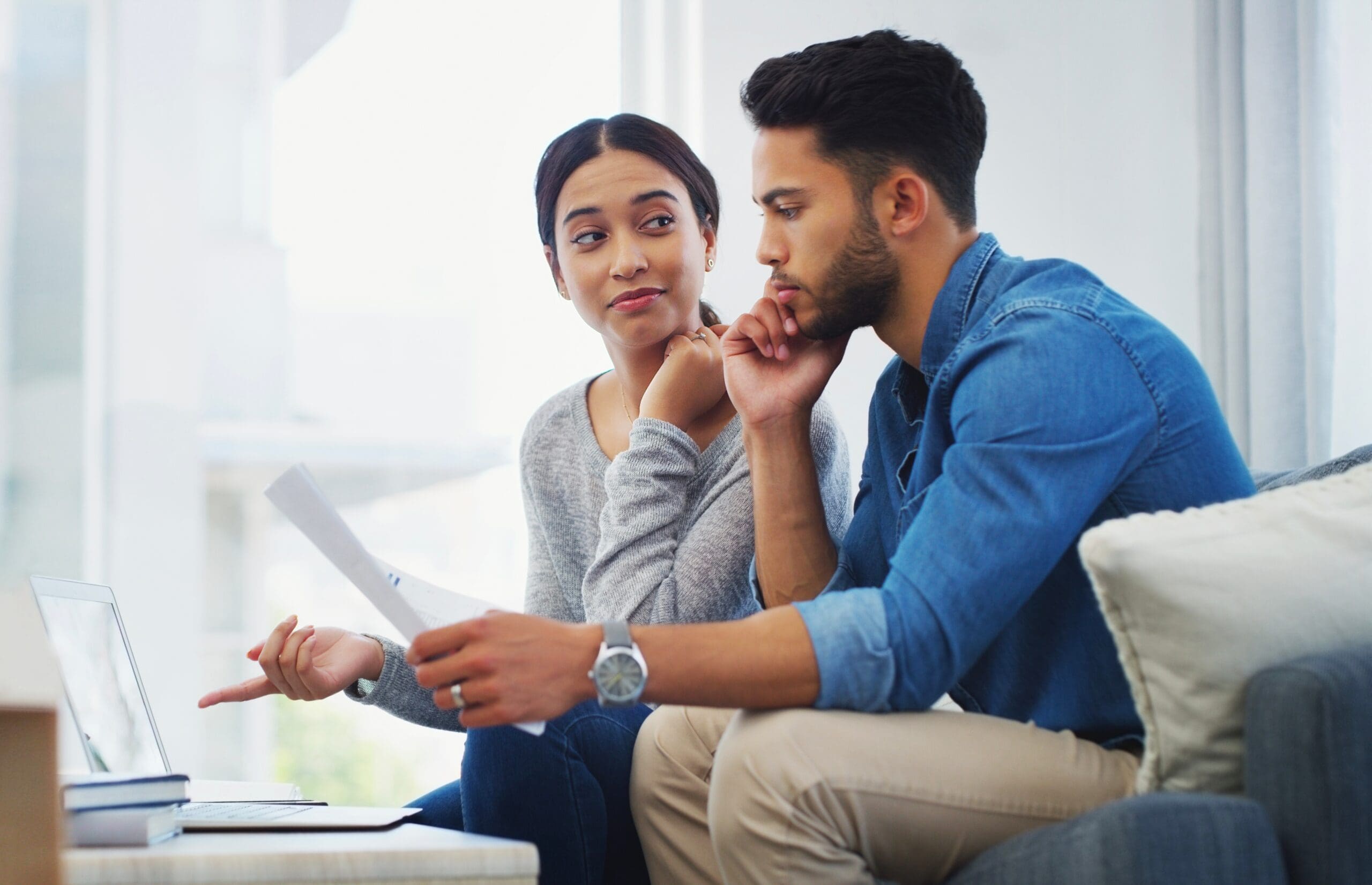 A couple, sitting on their couch, deciding whether to renovate their home, do an addition, or re-build.